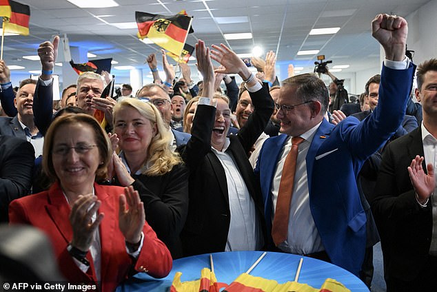 Members of the far-right AfD party cheer after the first exit polls were announced