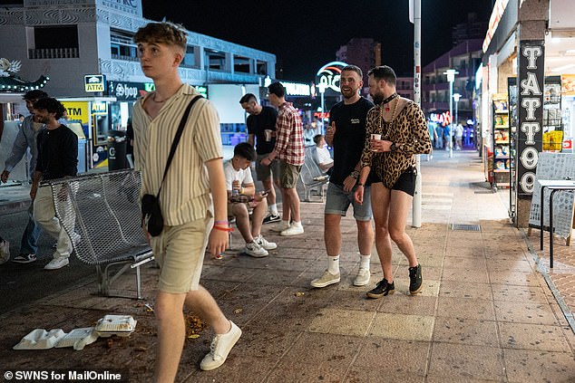 Partygoers walk down a street in Magaluf as they enjoy a Spanish getaway