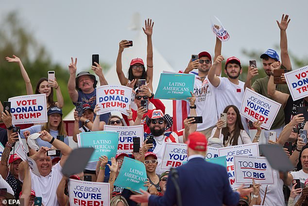 Donald Trump looks out at supporters holding 