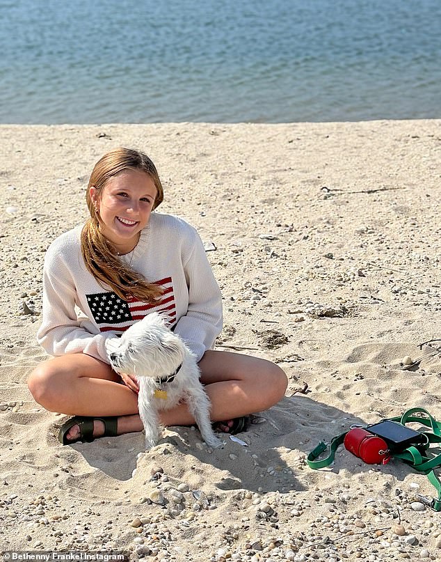 In one shot, the teen was seen on the beach wearing a white sweater with an American flag across it