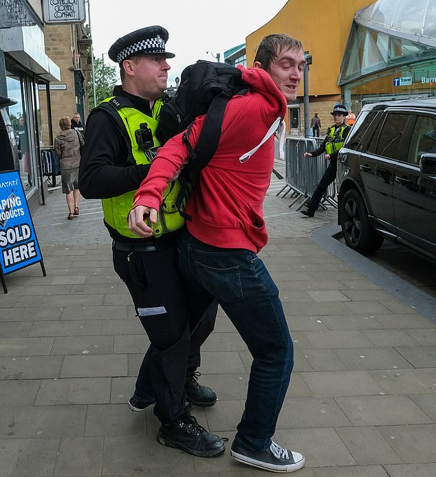 The man is wrestled by a police officer after running from the scene in Barnsley