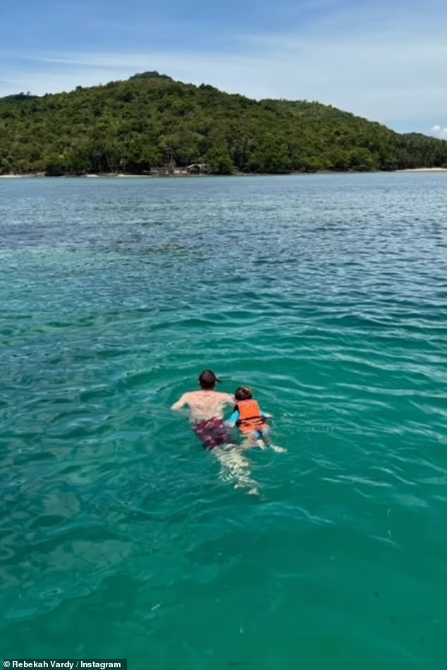 Jamie takes one of his youngest children for a dip in the ocean