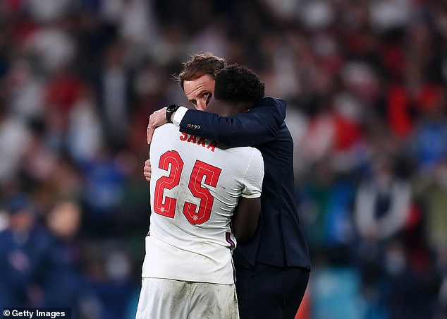 Bukayo Saka (front) hugs Gareth Southgate (back) after missing a penalty during the 2020 Euro Finals. The England star was then insulted online after the match