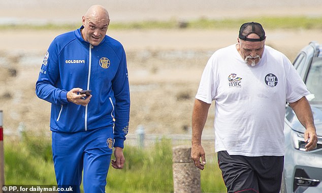 Fury was pictured with his father John (right) in his hometown in the aftermath of the fighting