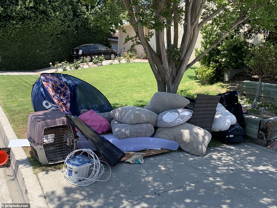 Piles of discarded furniture, cushions and other household items from the house were scattered outside in the otherwise well-maintained residential street