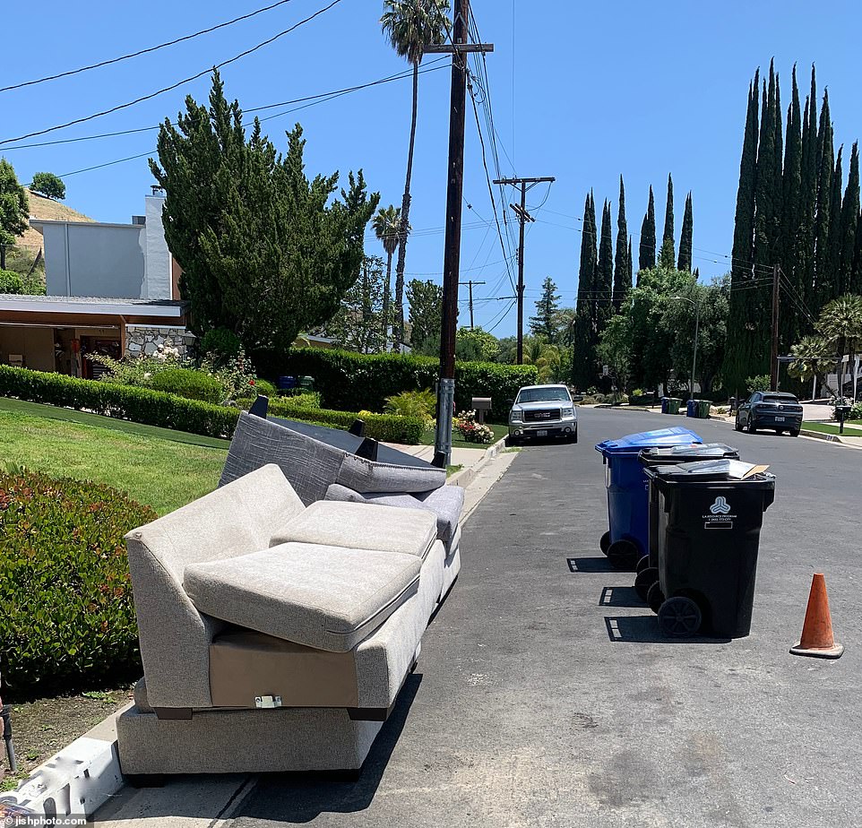 Some of the home furnishings, such as a taupe-colored sofa that was pictured in previous real estate photos of the property, can now be seen torn and soiled on the street, ready to be picked up by waste management.