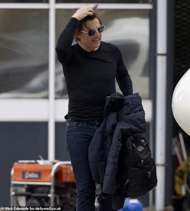 IMF agent Ethan Hunt looked stylish in black sunglasses as he tried to protect his hair from the wind at London's only heliport