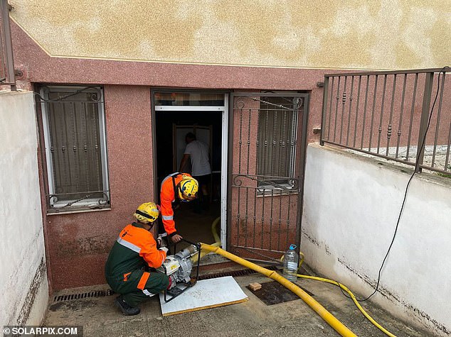 Emergency workers are busy pumping water from a building in Murcia