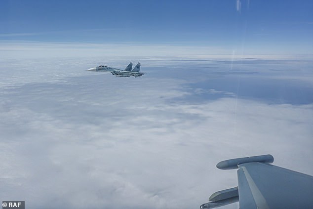 Last week, Britain's Typhoon jets teamed up with the German air force to intercept another Russian spy plane and a pair of fighter jets over the Baltic Sea.  Pictured: Last week a Russian Su-27 is seen flying out of the wing of an RAF plane