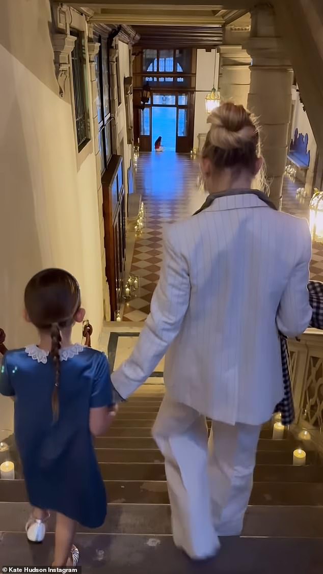 The video showed Rani wearing a muted blue satin dress with a white Peter Pan collar, while Hudson wore her patterned coat and at one point held her hand.