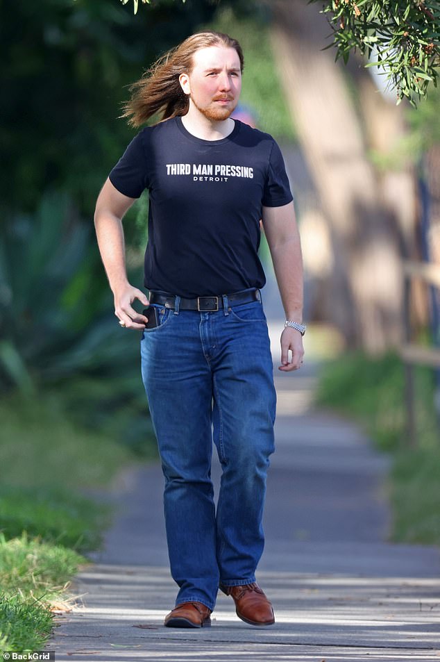 The son of Hollywood royalty looked every bit the cool guy as he walked down the street in a Third Man Pressing Detroit T-shirt and classic jeans.  He completed his look with a black belt, a stylish watch and brown shoes