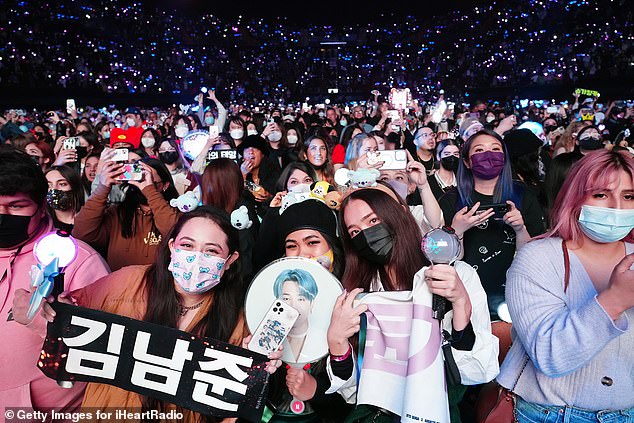 Concertgoers watch BTS perform on stage during iHeartRadio 102.7 KIIS FM's Jingle Ball 2021. The band has gained a cult following among K-pop fans since its inception in 2010.