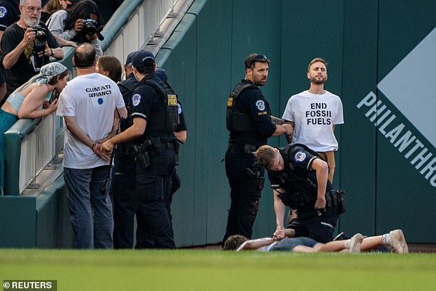 The group – from Climate Defiance – wore shirts that read 'End Fossil Fuels' while handcuffed