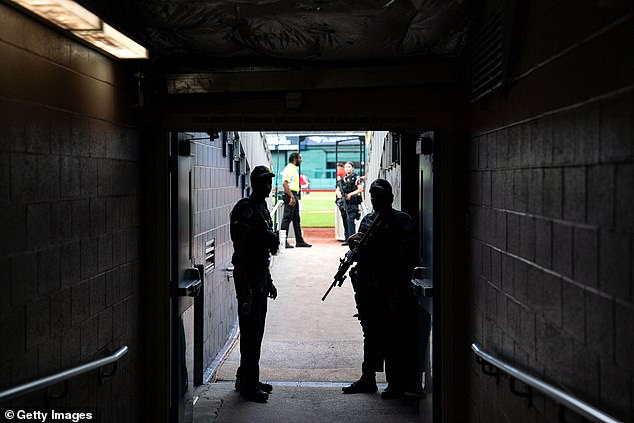 Before the game, a police officer stands in the tunnel at Nationals Park with his gun