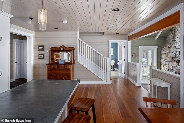 Just off the living room is a large eat-in kitchen with the same hardwood, ceiling lighting, slate countertops and a zinc wrapped island