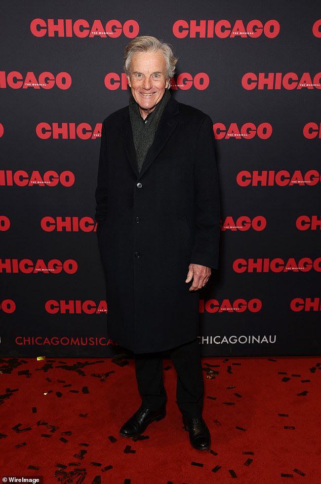 Sound of Music star Nicholas Hammond dressed in a classic black overcoat, layered over a dark gray scarf and black trousers