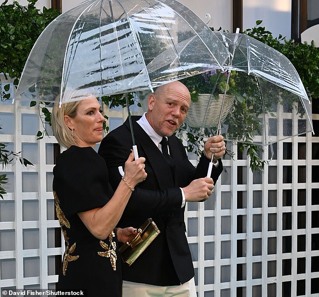 The couple was protected from the summer rain thanks to a pair of huge parasols