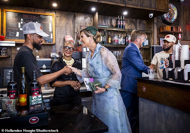 Queen Máxima shakes hands with a local entrepreneur in a coffee shop in East Flabush