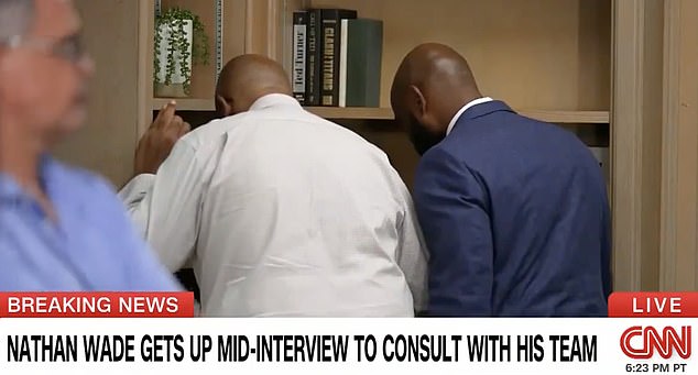 The media consultant (left) and Nathan Wade (right) huddled in the corner of the room as CNN rolled the cameras.  When he returned he continued to refuse to give a straight answer about the timeline of his affair with Fani Willis