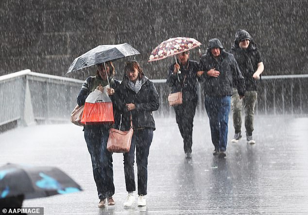 A high chance of rain between 5 and 15 mm is expected for Sydney from the afternoon and evening, with highs of 17 degrees on Friday (photo, people are soaked in Melbourne)