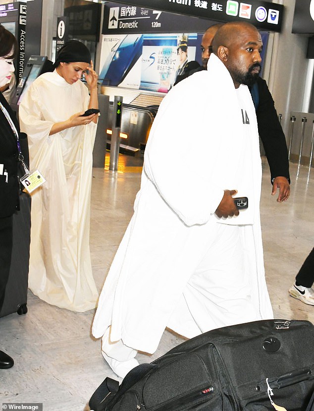 On June 9, Censori wore a more opaque version of her cloak at the airport, while West wore the same shirt