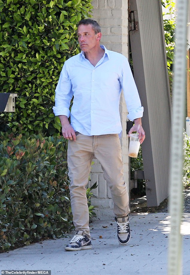 He wore a light blue button-down shirt with the sleeves rolled up to his elbows, khaki pants and dark blue sneakers.