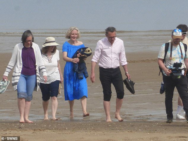 Michael Mosley is seen with his wife Clare and others, including a camera crew, in Colwyn Bay, North Wales, on May 10, just weeks before his disappearance in Symi, Greece