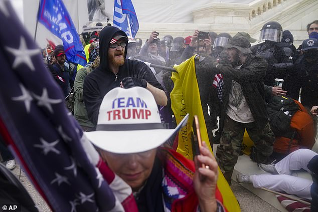Insurrectionists loyal to President Donald Trump attempt to breach a police barrier at the Capitol in Washington on January 6, 2021