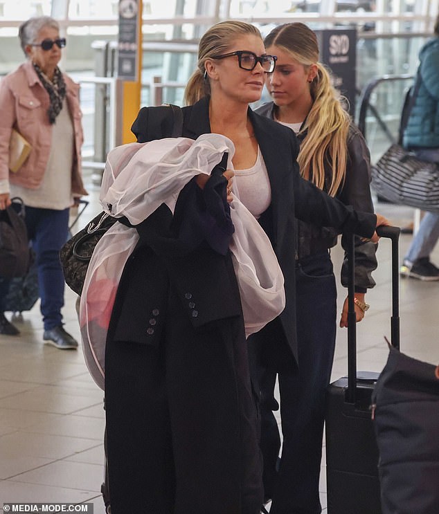 Natalie's brunette hair was worn in a ponytail and she appeared in good spirits as she chatted with her look-alike daughter as they made their way through the busy airport