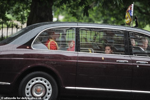 Princess Charlotte looks out the window as the family arrives at Buckingham Palace today