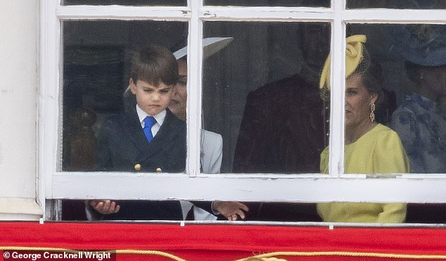 Prince Louis, known for his cheeky antics, tries to open a window during Trooping the Color today