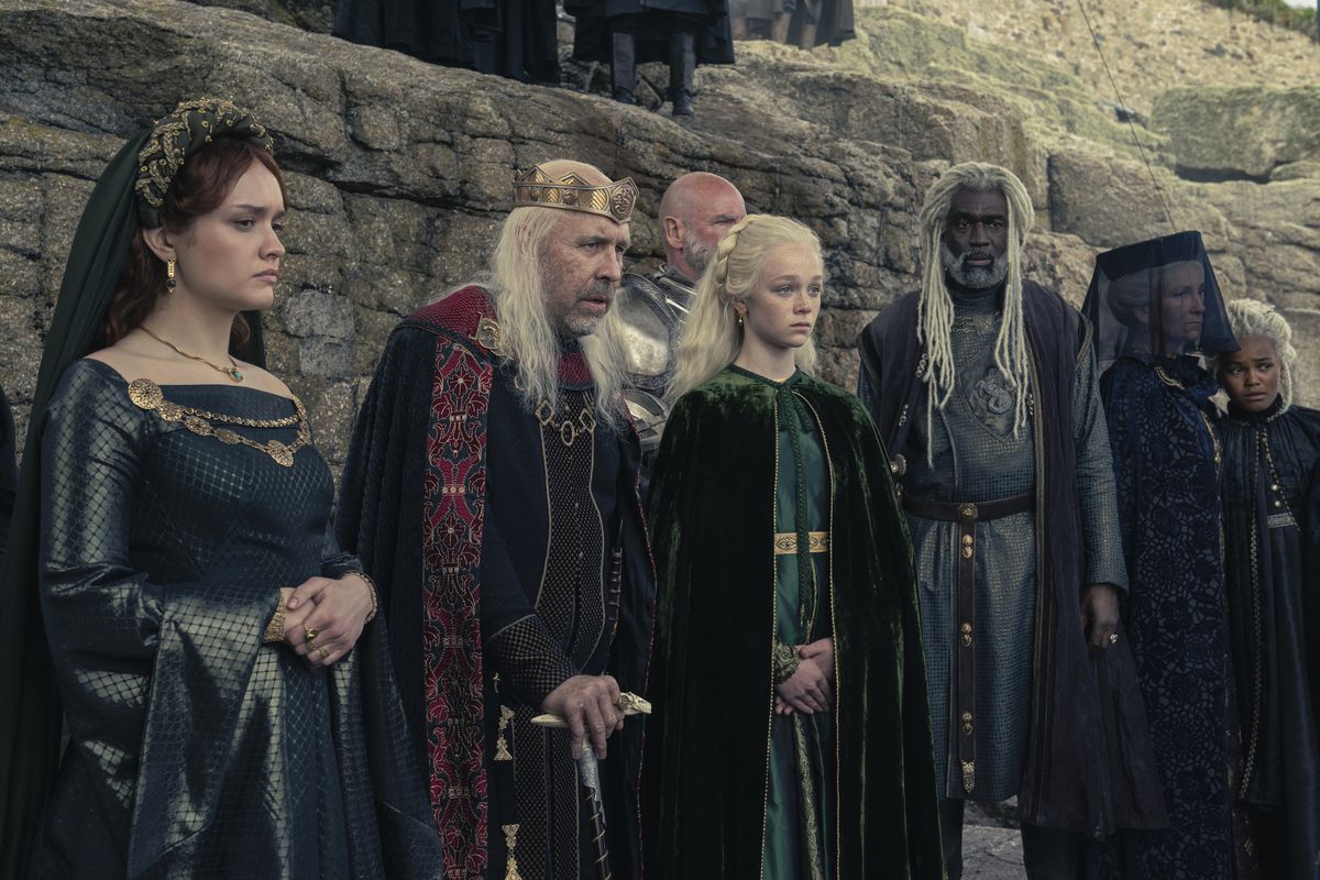 Alicent, Viserys, Helaena, Corlys, Rhaenys and Baela stand in a row and look somber