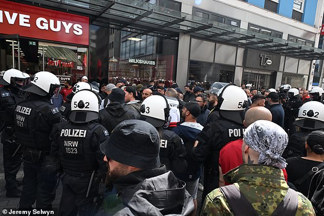 The black-clad thugs ran amok in central Dortmund this afternoon, targeting a fast-food restaurant and then clashing with riot police.