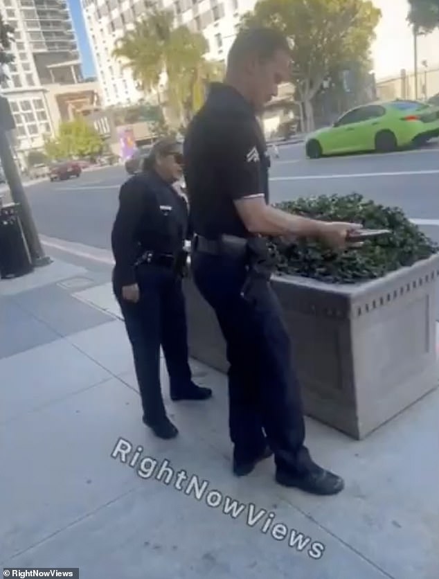 An LAPD officer picked the gun up from the ground and inspected it before removing the magazine from the gun which appeared to be loaded