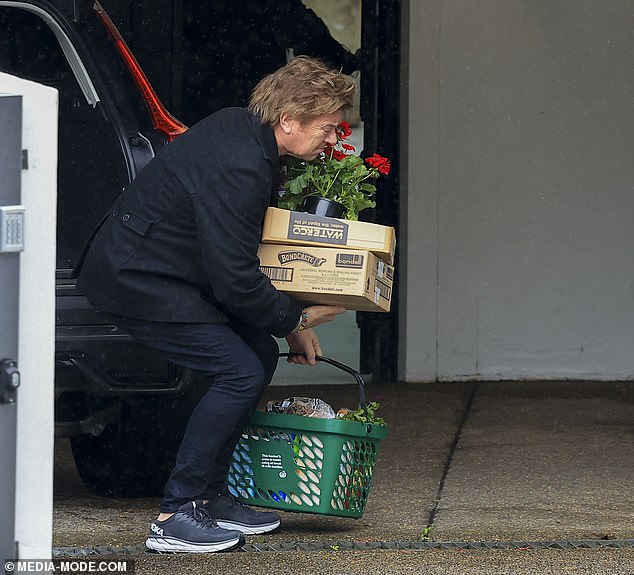 The 69-year-old television star was photographed on Saturday unpacking his groceries, including a box of potted flowers and other items, from his car.