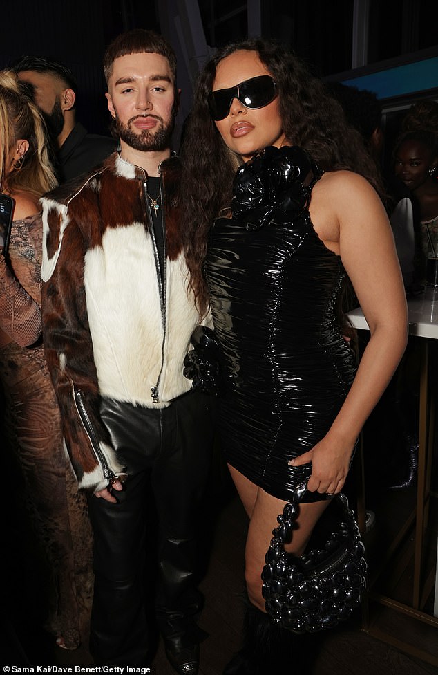 Jade complemented her edgy look with statement black glasses and a trendy chain handbag (pictured with birthday boy Jamie)