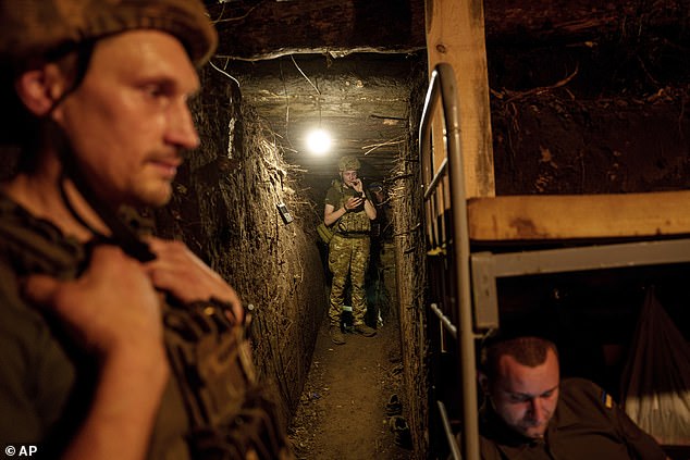 Ukrainian National Guard soldiers from the Khartia Brigade take cover after firing on Russian positions