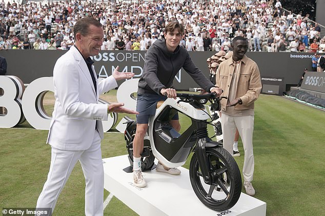 The awards ceremony was bizarre and involved Draper sitting on an e-motorcycle next to TikTok star Khaby Lame (right)