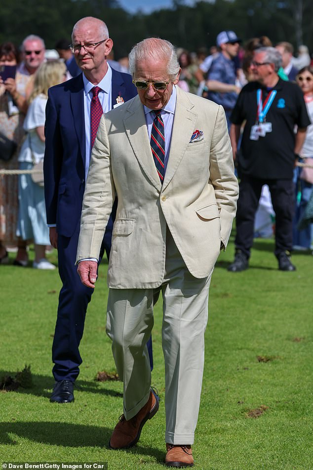 Charles wore his favorite Moscot sunglasses paired with a lightweight beige suit, a neat navy blue, red and gold striped tie and brown suede shoes