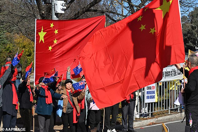 Peaceful supporters of Tibet, a predominantly Buddhist region in China's far west, were swarmed by counter-protesters who unfurled huge Chinese and Australian flags to hide them from view