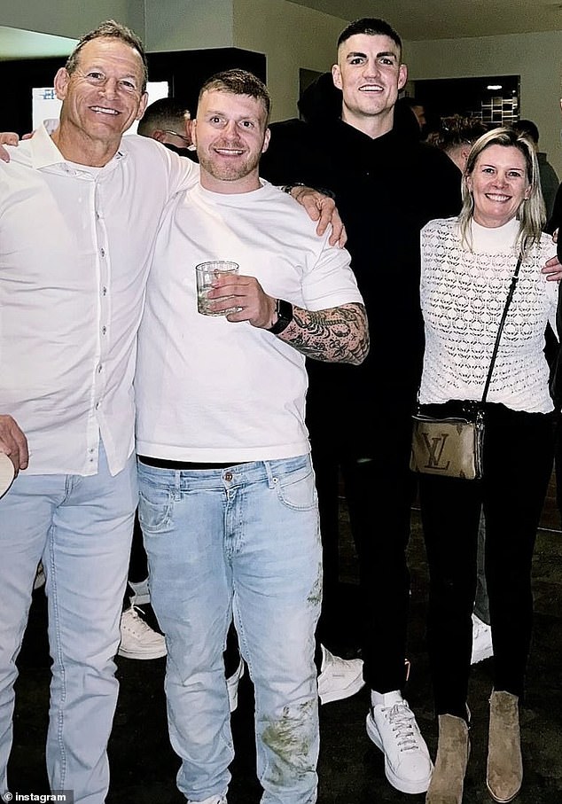 The pitch invader, second from left, posed for a photo with Maynard after the game with the Marvel Stadium stains still on the leg of his jeans
