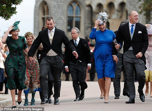 Peter Phillips (2L), Autumn Phillips (L), Zara Tindall (2R) and Mike Tindall (R) also battle the wind at the wedding of Princess Eugenie and Jack Brooksbank