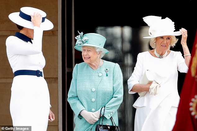 Melania Trump (L) and Camilla, Duchess of Cornwall hold their hats during the ceremonial welcome in the Buckingham Palace Garden for President Trump in 2019