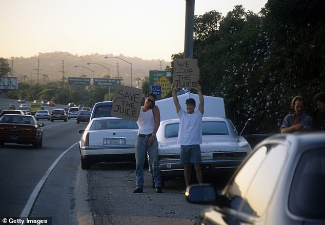 Motorists wave 'Save the Juice' signs as police cars chase the Bronco driven by Cowlings