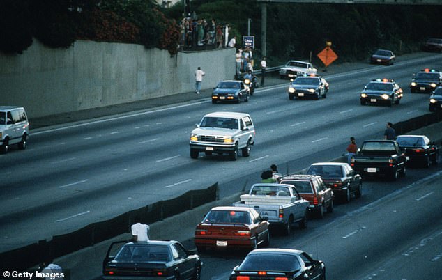 Motorists stop and wave as police cars chase the Ford Bronco carrying OJ Simpson