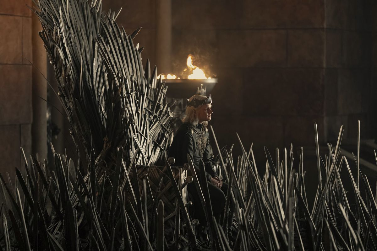 Young King Aegon sits on the Iron Throne, nearly engulfed by the swords surrounding it in the season 2 premiere of House of the Dragon.