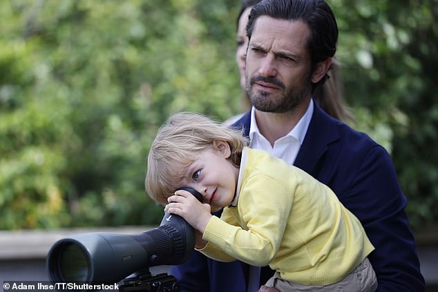 Supported by his father, Prince Carl Philip, the three-year-old prince looked through a huge telescope