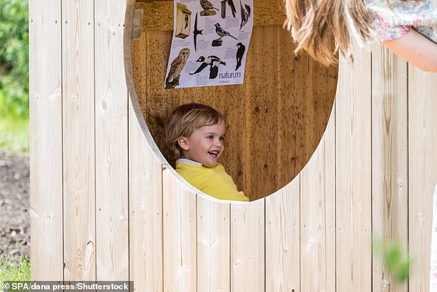 A smiling Prince Julian at one point hid in the wooden Wendy house as his mother, Princess Sofia, looked on