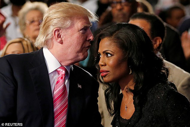 Then Republican candidate Donald Trump (left) whispers to Omarosa (right), a three-time alumna of his reality show The Apprentice, as they appear together during a campaign stop in Detroit, Michigan in September 2016.