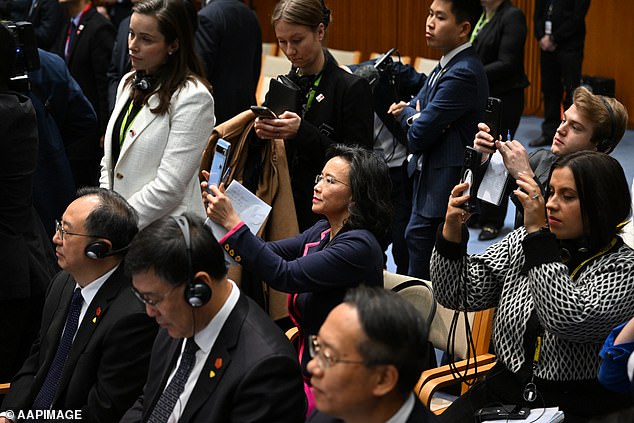An Australian media official (pictured in the cream blazer) came to Ms Lei's aid and 'wedged' herself between Ms Lei and another Chinese official in an attempt to block her view